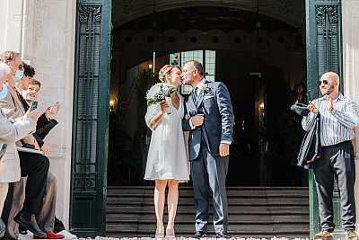 Les mariés s'embrassent à la sortie de la mairie