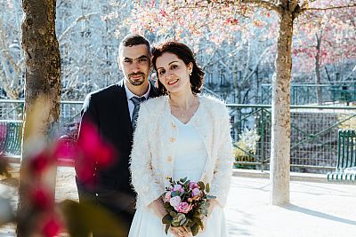 Le couple de mariés pose dans un parc fleuri