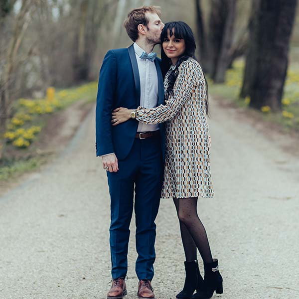 Le couple enlacé dans un chemin bordé de verdure