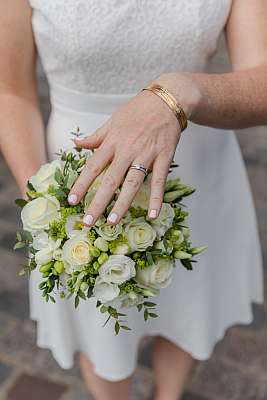 Gros plan de l'alliance et du bouquet de la mariée