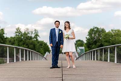 Les mariés posant sur un pont pour la séance de couple