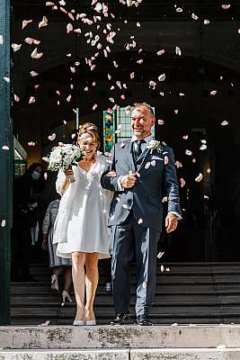 Le couple sous les confettis à la sortie de la mairie