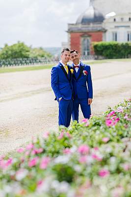 Photo des mariés entre les fleurs et le château