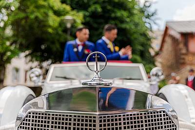 Mariage gay - Les mariés posant dans une voiture Excalibur