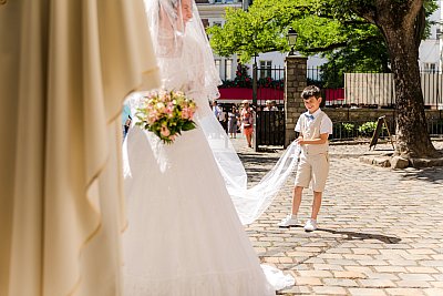 Le garçon d'honneur tient le voile de la mariée