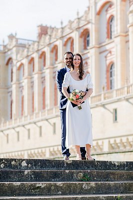 Les mariés enlacés posent devant le château