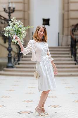 La mariée avec son bouquet pose devant les escaliers en marbre de la mairie du 18ème arrondissement de Paris