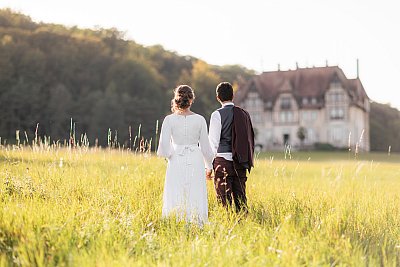 Les mariés main dans la main au soleil couchant