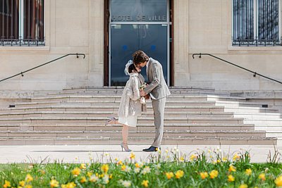 Les mariés devant la mairie adoptent la pose traditionnelle des photos de mariage