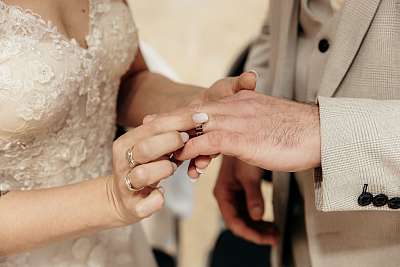 Gros plan sur la mariée mettant l'alliance au doigt du marié