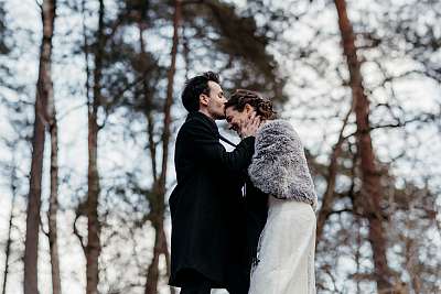 Le baiser sur le front de la mariée dans la forêt