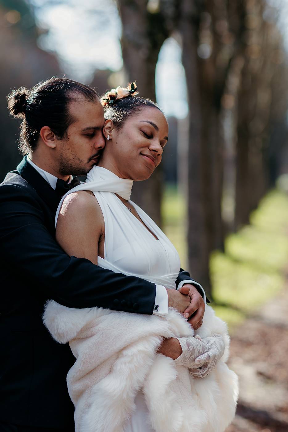Baiser dans le cou de la mariée au parc de Saint-Cloud