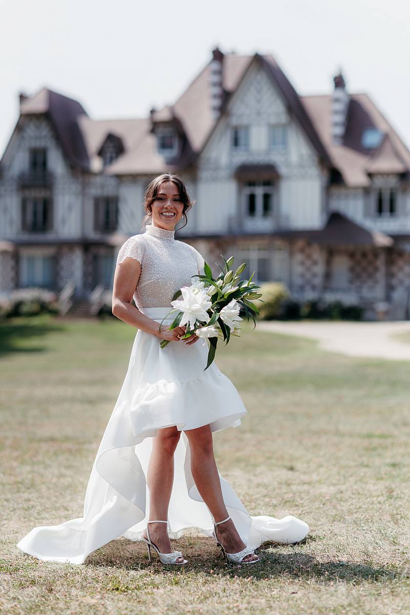 La mariée et son bouquet devant la maison des Buissons