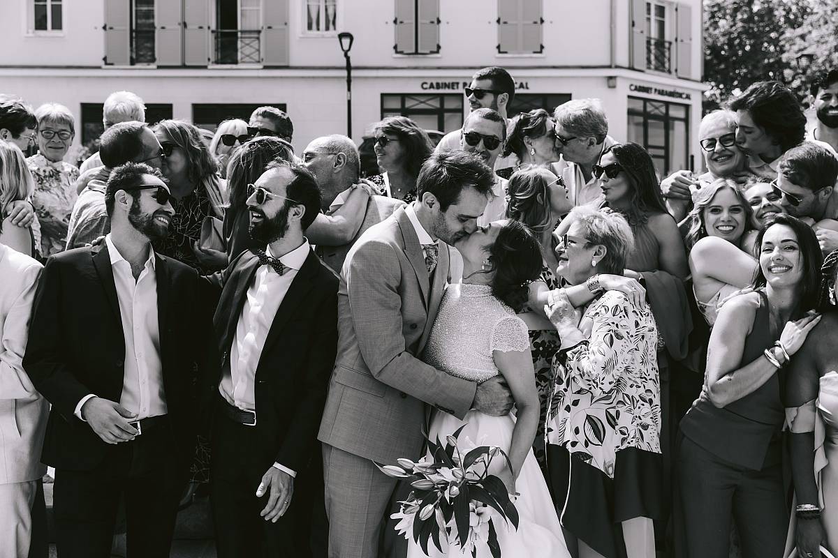 Photo de groupe avec les mariés et leurs invités s'embrassant ou se faisant un câlin