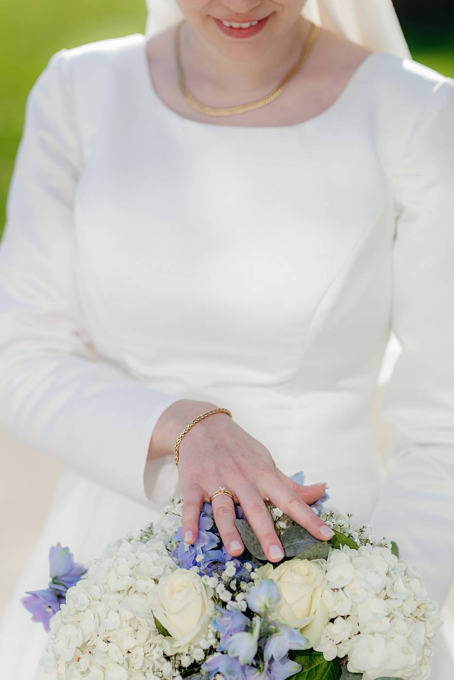 Gros plan sur l'alliance de la mariée et de son bouquet