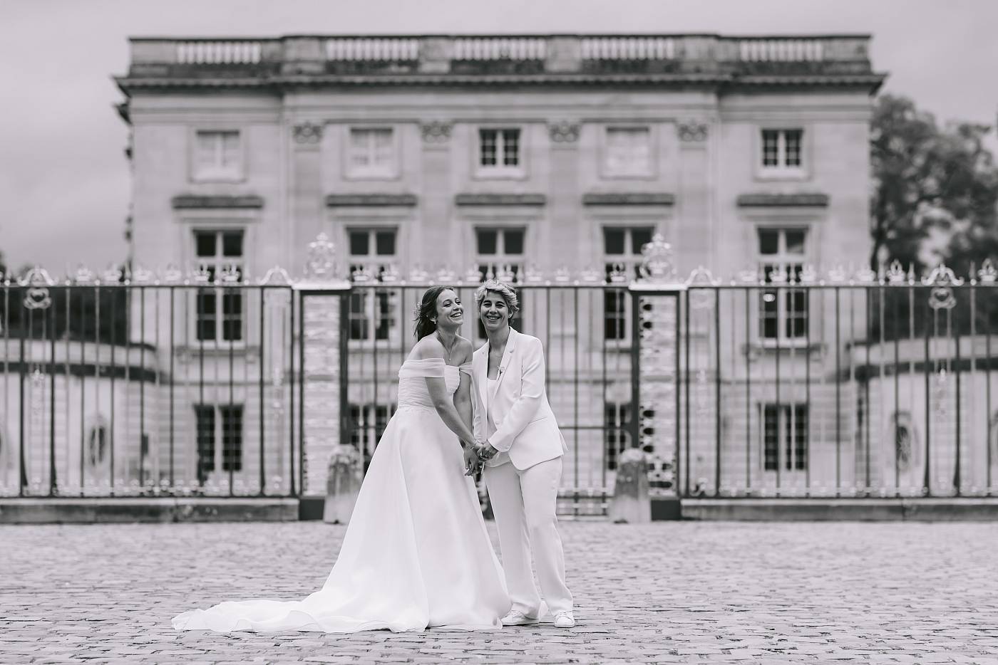 Fou rire des mariés devant le petit Trianon lors de la séance photo de couple