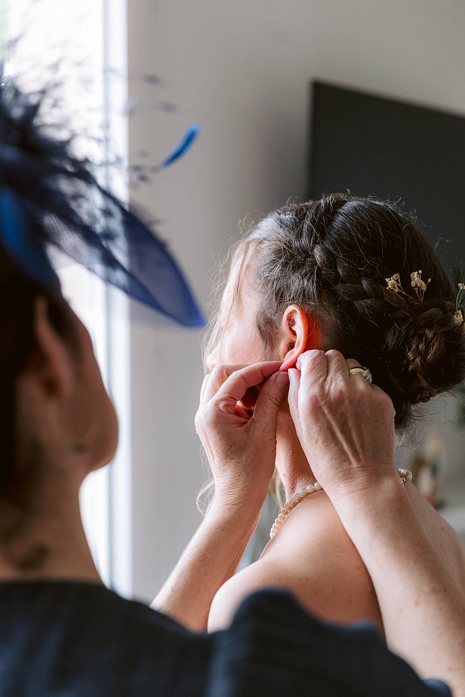 La mère de la mariée attache les boucles d'oreille