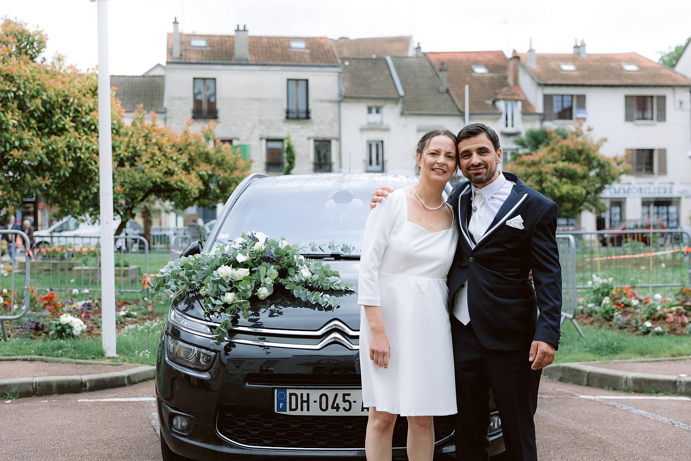 Les mariés arrivent dans leur voiture décorée pour l'occasion