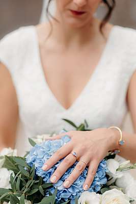Gros plan sur le bouquet et l'alliance de la mariée