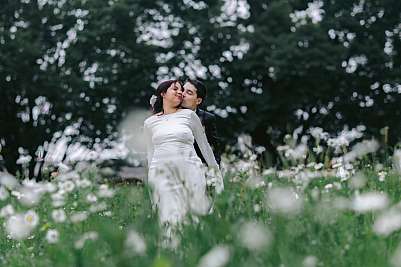 Photo de couple sous la pluie au milieu des fleurs