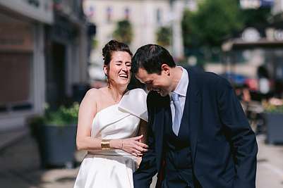 Les mariés pliés de rire pendant la séance photo de couple