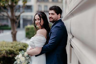Pose des mariés devant la façade en pierre de la mairie de Neuilly