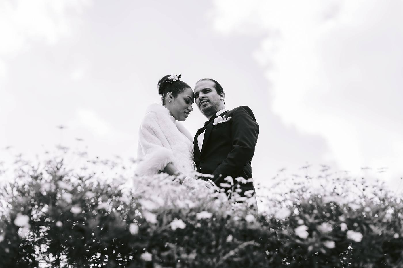 Les mariés prennent la pause devant un parterre de fleurs au domaine national de Saint-Cloud