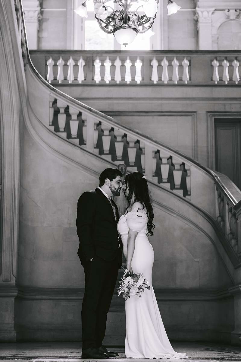 Les mariés devant l'escalier menant à la salle des mariages