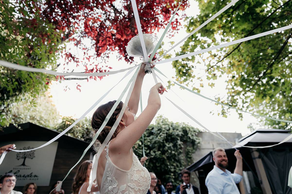 La mariée coupe le ruban pendant le jeu du bouquet