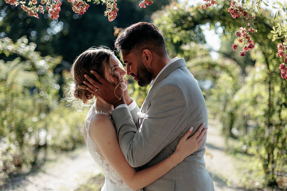 Photo de couple des mariés les yeux dans les yeux à la roseraie du Val-de-Marne
