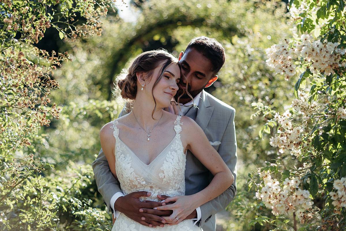 Photo de mariage devant une arcade de roses