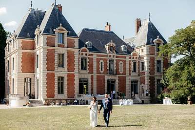 Les mariés main dans la main dans la pelouse du château de Gavoy