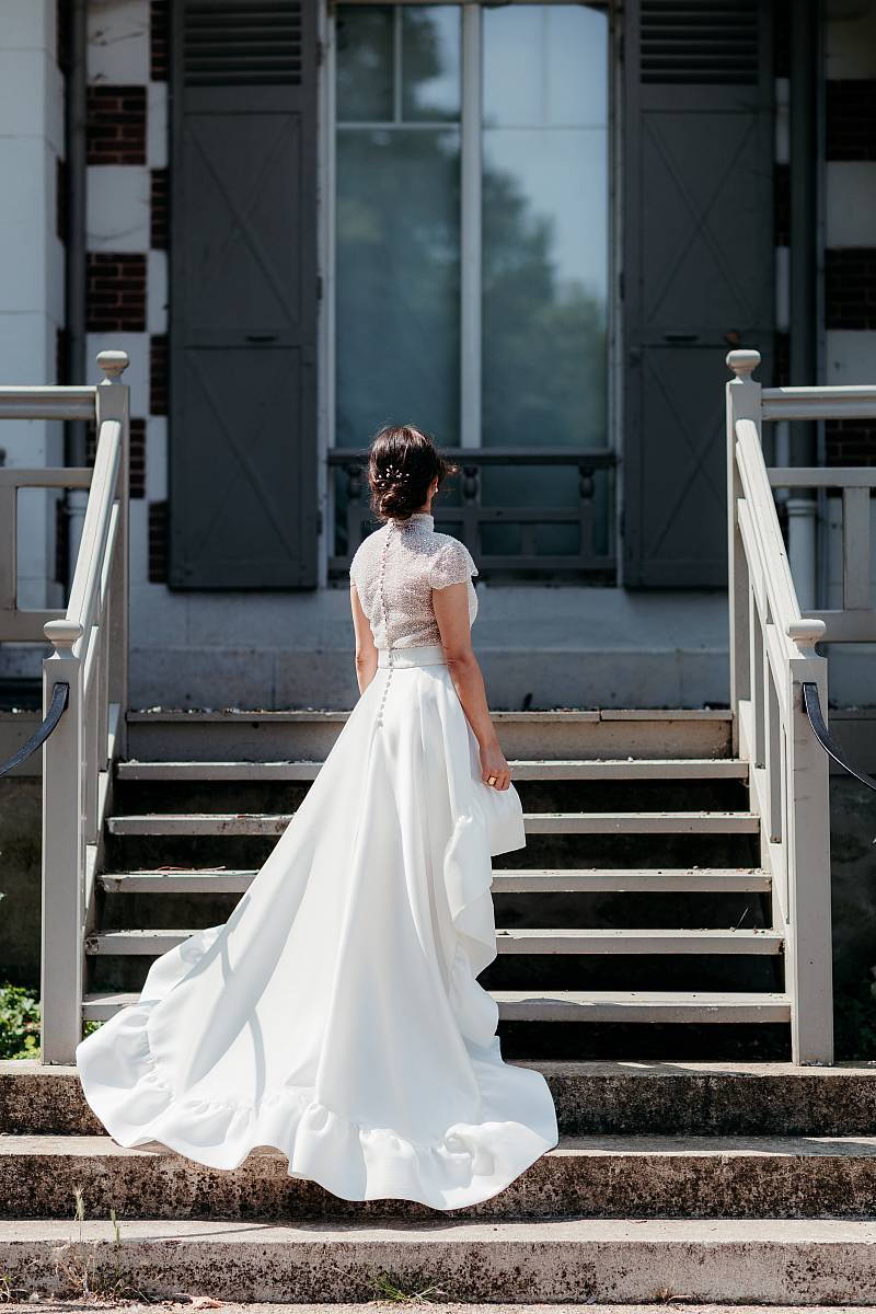La mariée et sa traîne dans les escalier de la maison des Buissons