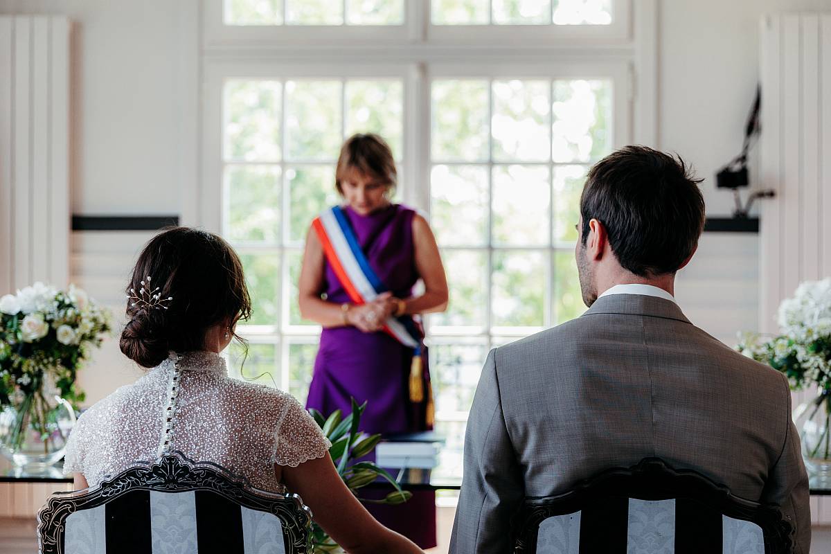 Les mariés de dos devant la maire