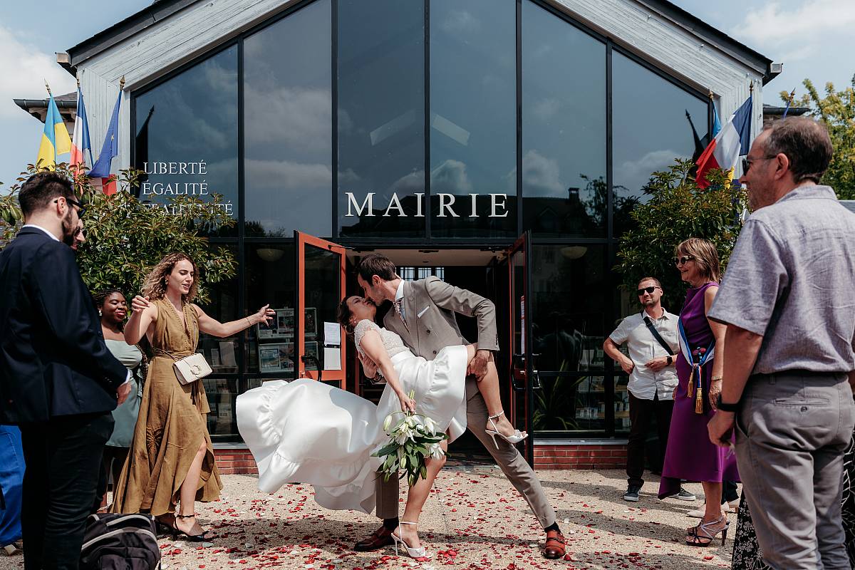 Le superbe tableau du marié embrassant la mariée avec sa traîne dans les airs