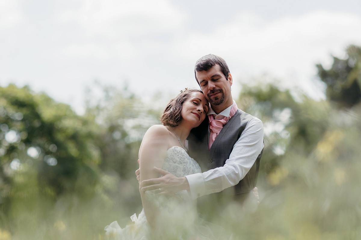 Pose romantique du couple dans le jardin à l'anglaise du domaine de Saint-Germain-en-Laye