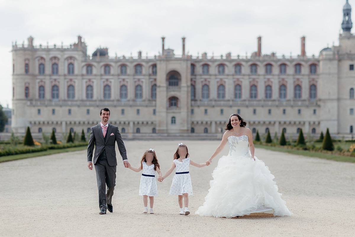 Le couple et leurs filles marchant main dans la main devant le château de Saint-Germain-en-Laye