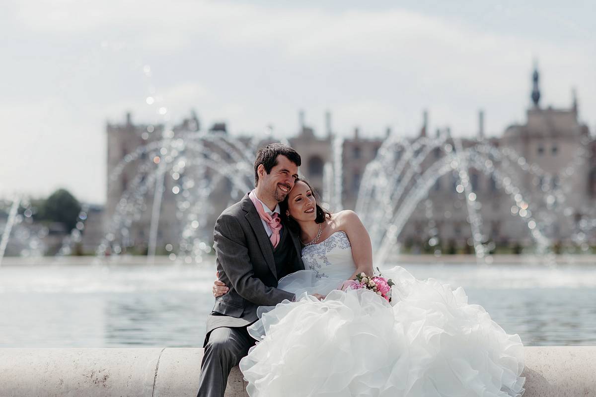Le couple au bord de la grande fontaine royale avec les jets d'eau