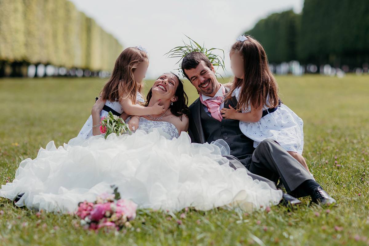 Les filles chatouilles leurs parents dans la grande pelouse du parc de Saint-Germain-en-Laye