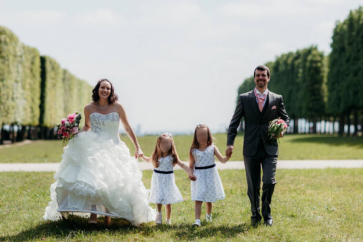 La famille marche main dans la main dans la pelouse du parc de Saint-Germain-en-Laye