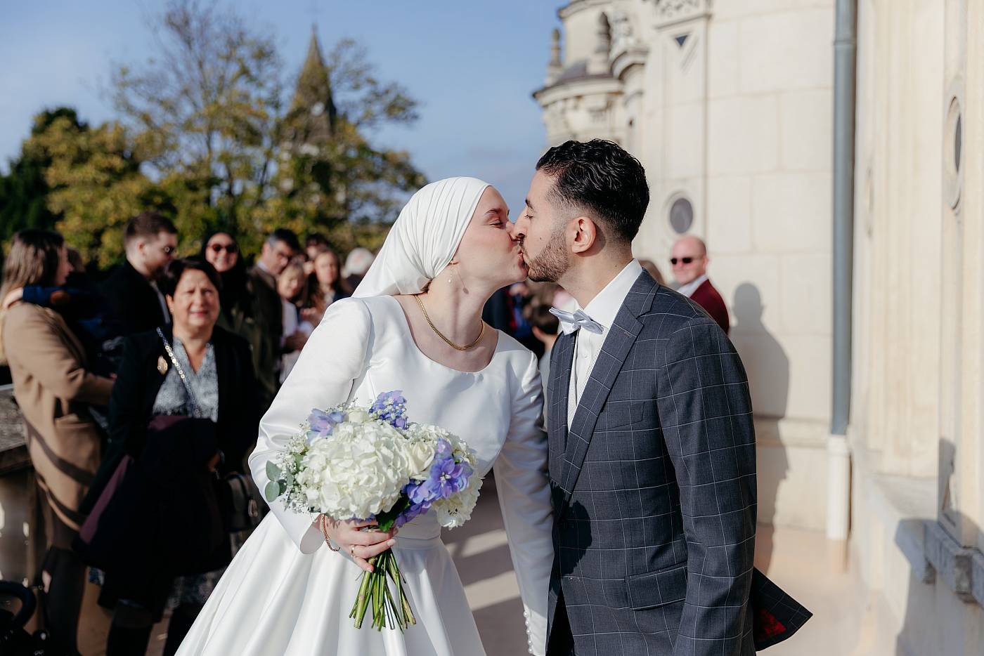 Le baiser des mariés après la sortie de la cérémonie de mariage