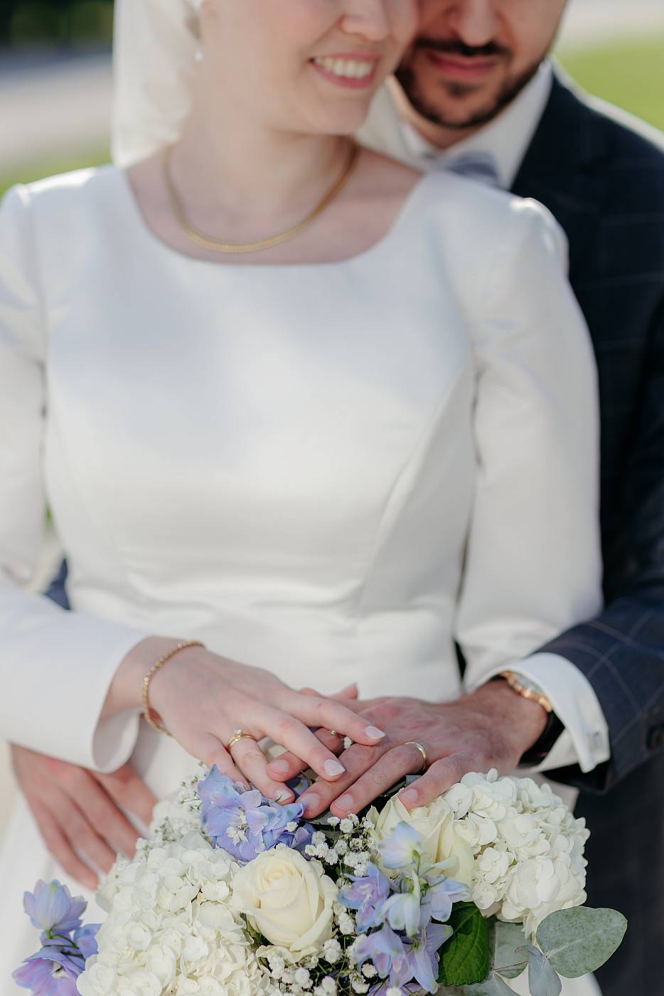 Les mariés posent leurs main sur le bouquet