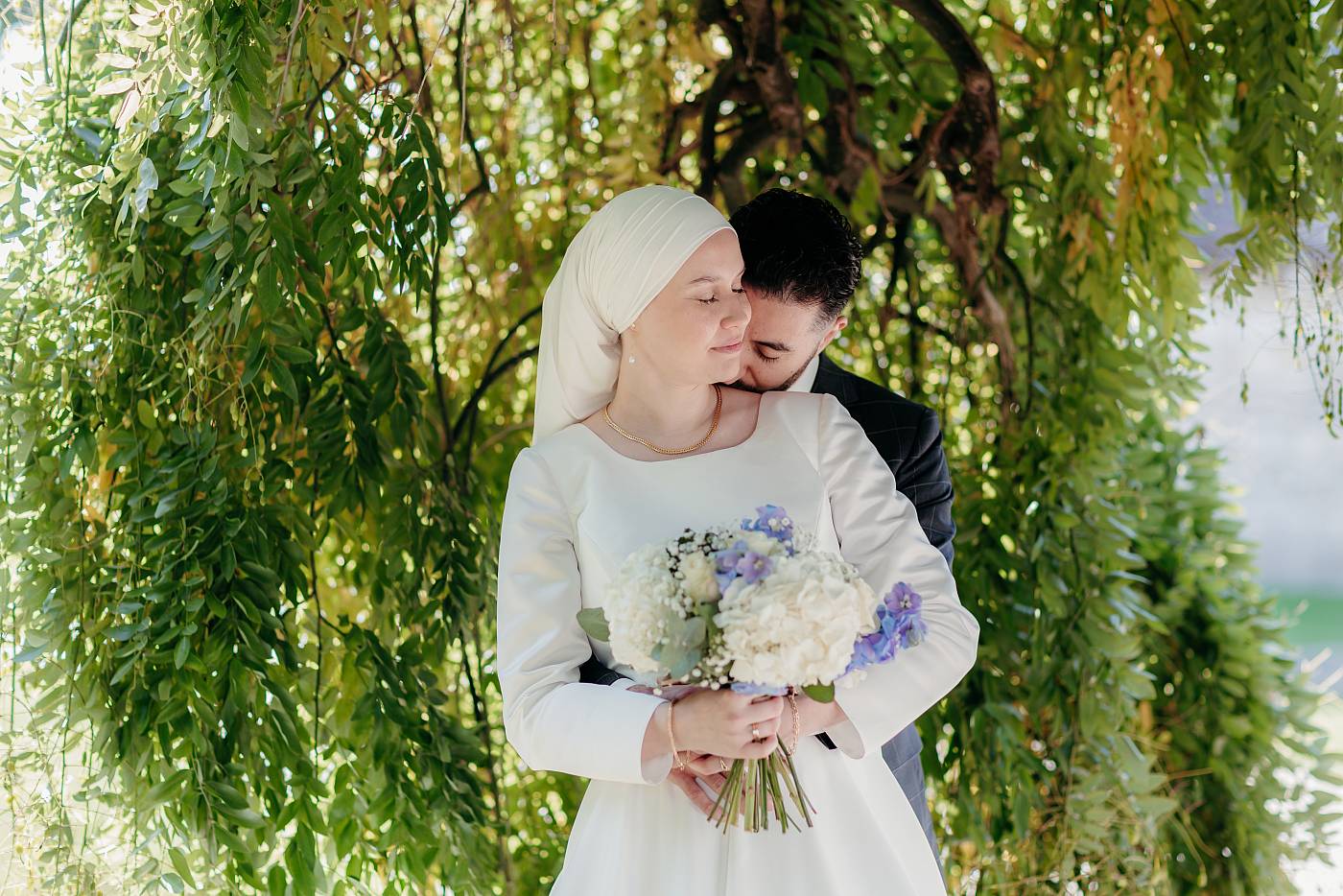 Petit moment d'affection entre les mariés sous le saule pleureur