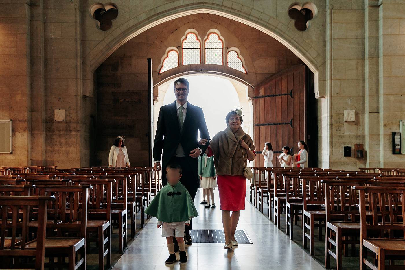 Le marié entre dans l'église accompagné par sa mère