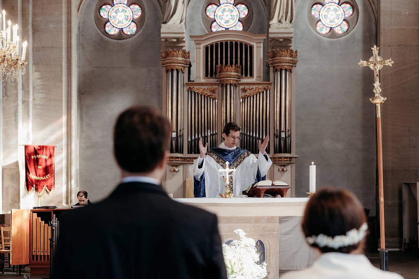 Les mariés de dos face au prêtre