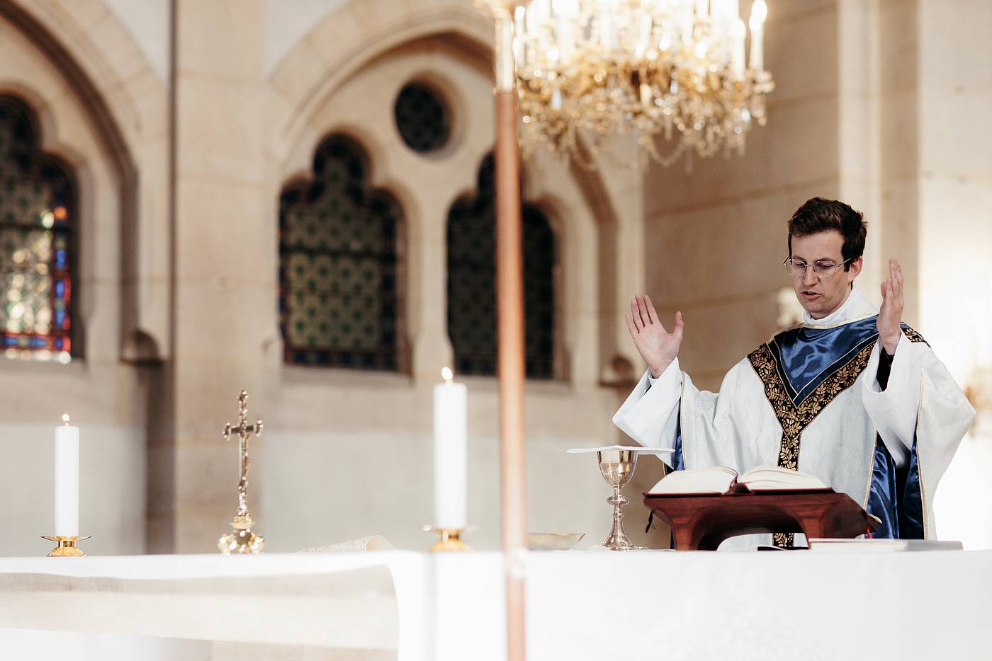 Le prêtre a les mains levées durant la cérémonie