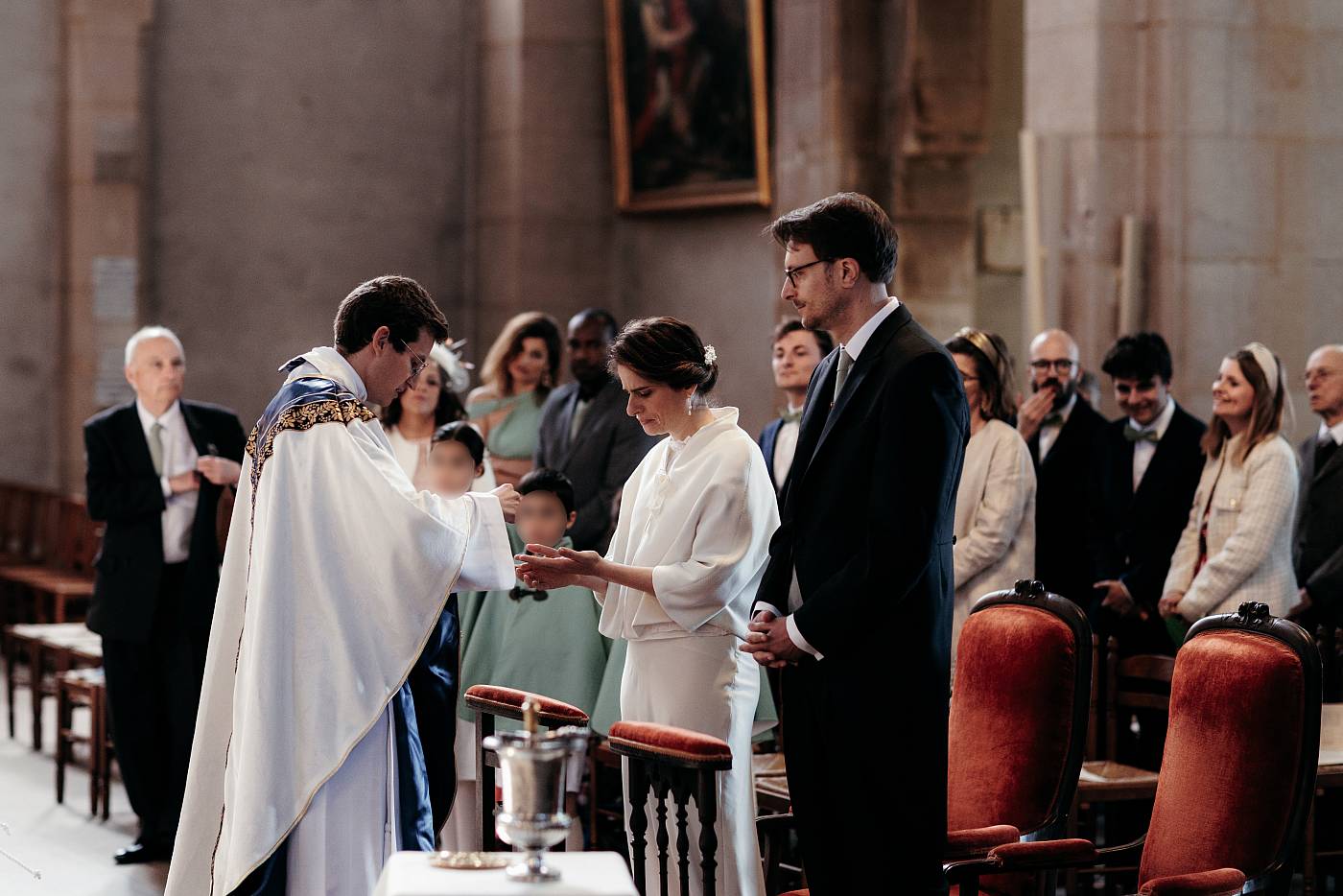 Le prêtre distribue les hosties aux mariés