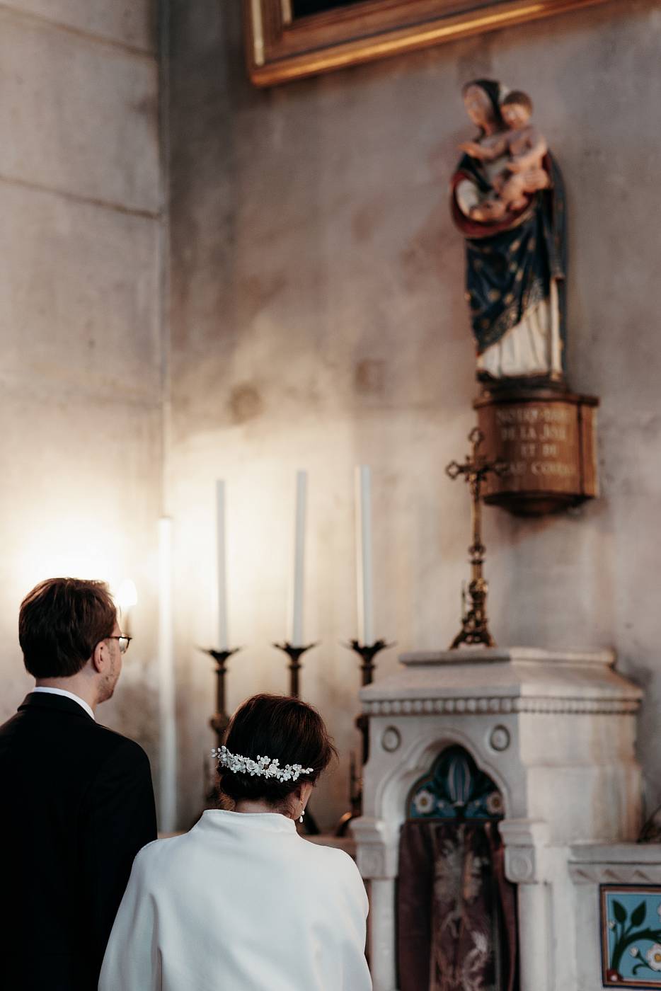 La mariée offre son bouquet à la vierge