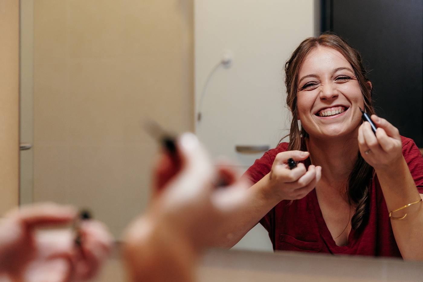 La mariée s'amuse pendant sa séance de maquillage