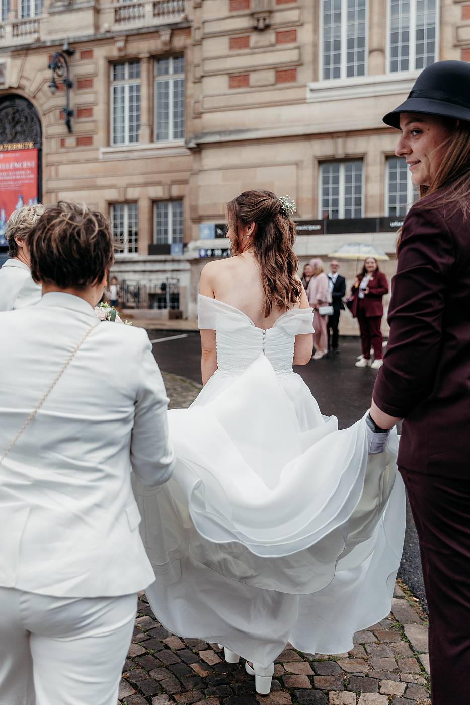 Les demoiselles d'honneur aident la mariée avec sa traine